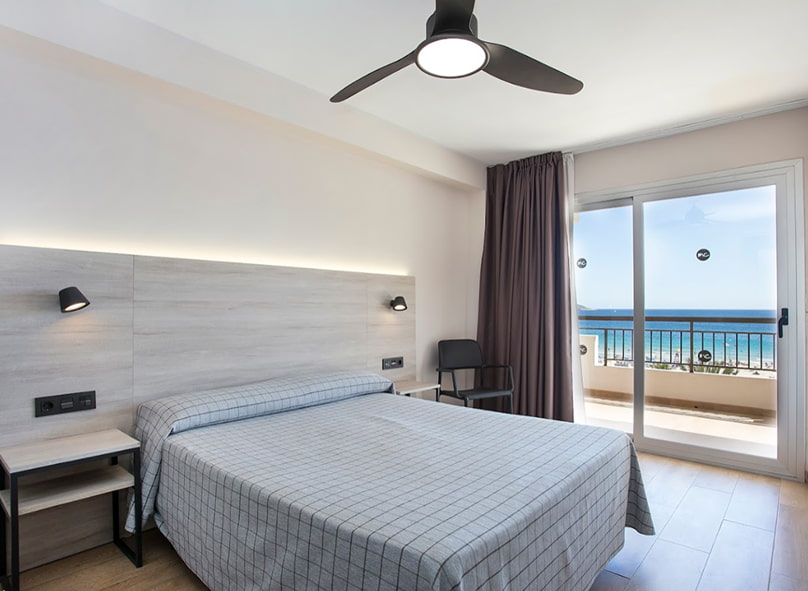 Cama doble junto a armario abierto, con caja fuerte