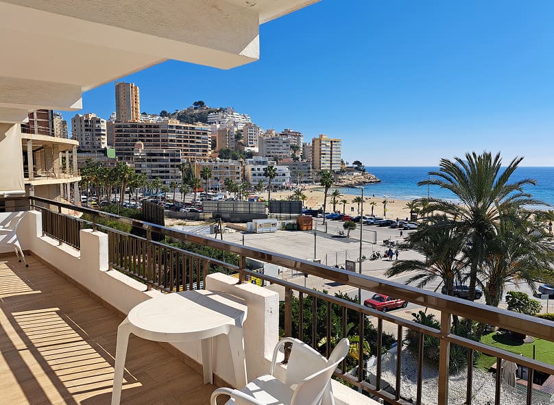 Dormitorio doble, con colchas blancas con cuadros y vistas direcatas al mar