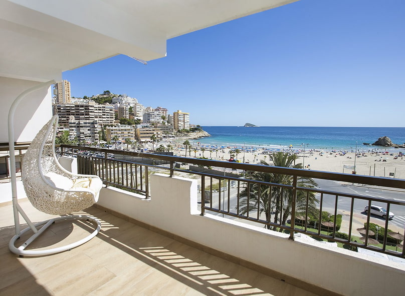 Terraza equipada con mesas y sillas, y vistas frontales al mar