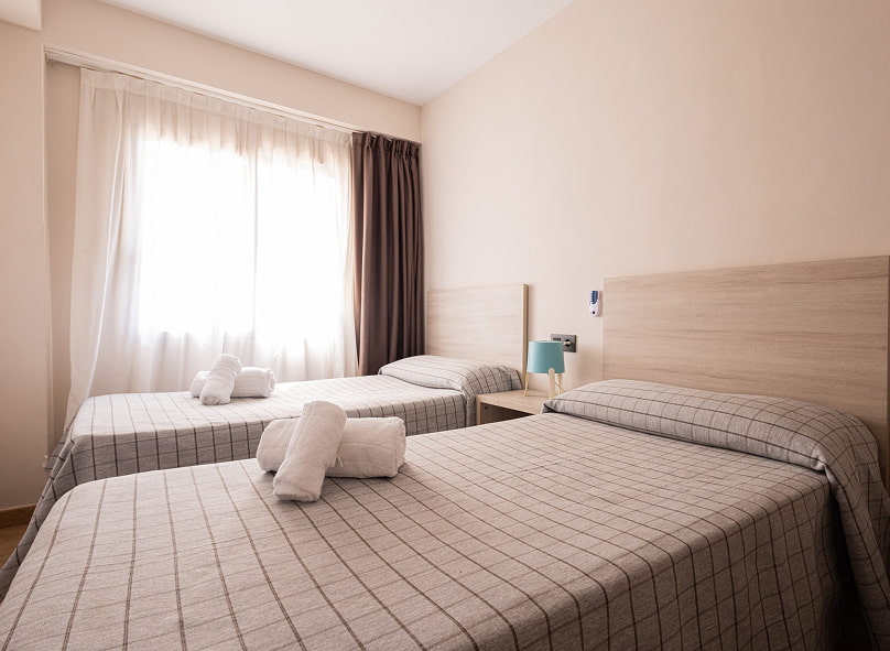 Habitación con dos camas individuales separadas por una mesita de noche