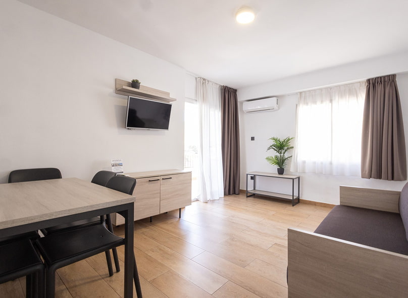 Habitación con cama doble, con colcha blanca a cuadros