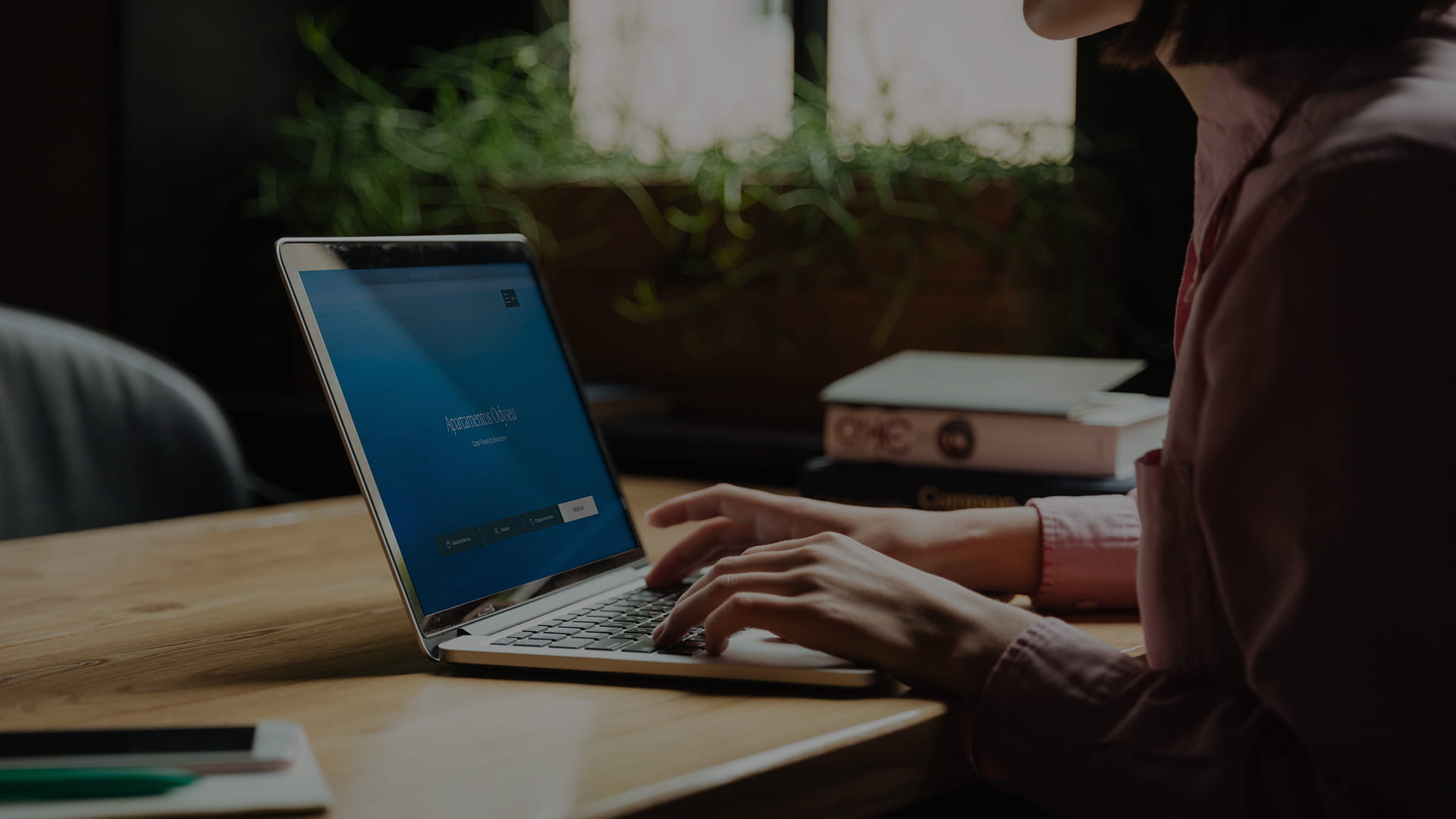 Mujer consultando la web de los apartamentos desde un portátil