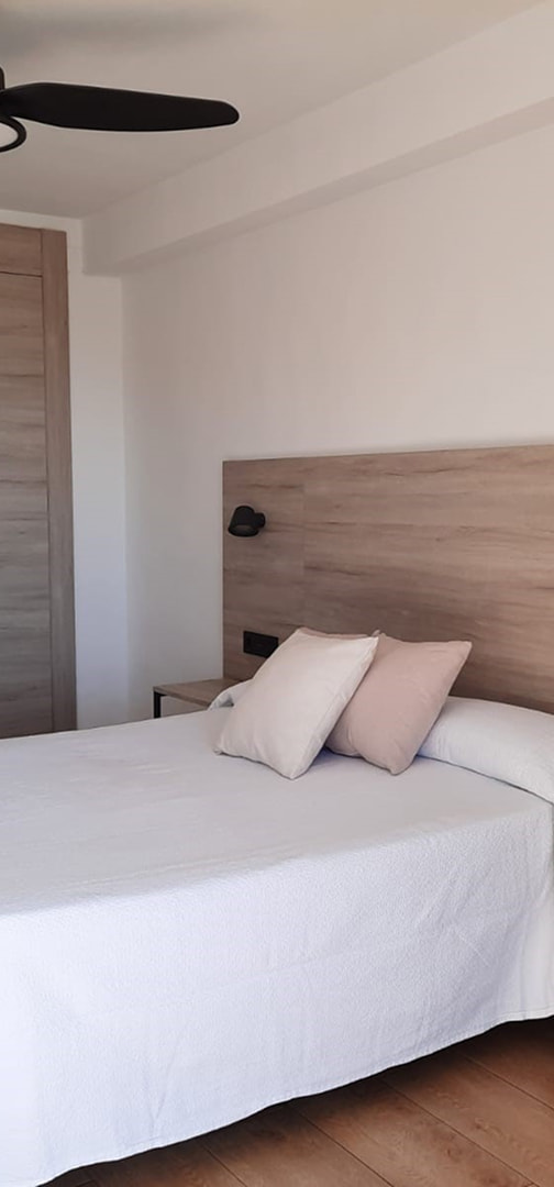 Toallas de baño enrrolladas a los pies de la cama