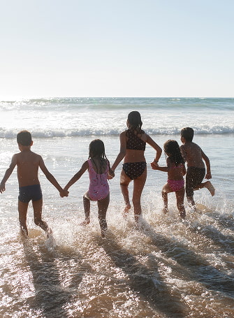 Grupo de niños entrando en el mar
