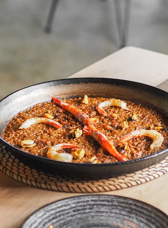 Deliciosa paella de marisco servida sobre la mesa de un restaurante