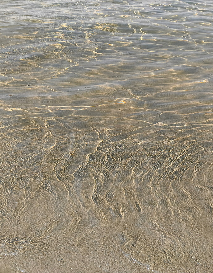 Detalle de agua cristalina que deja ver la arena del fondo