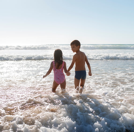 Cala Finestrat | Niños Pareja de niños entrando en el agua cogidos de la mano